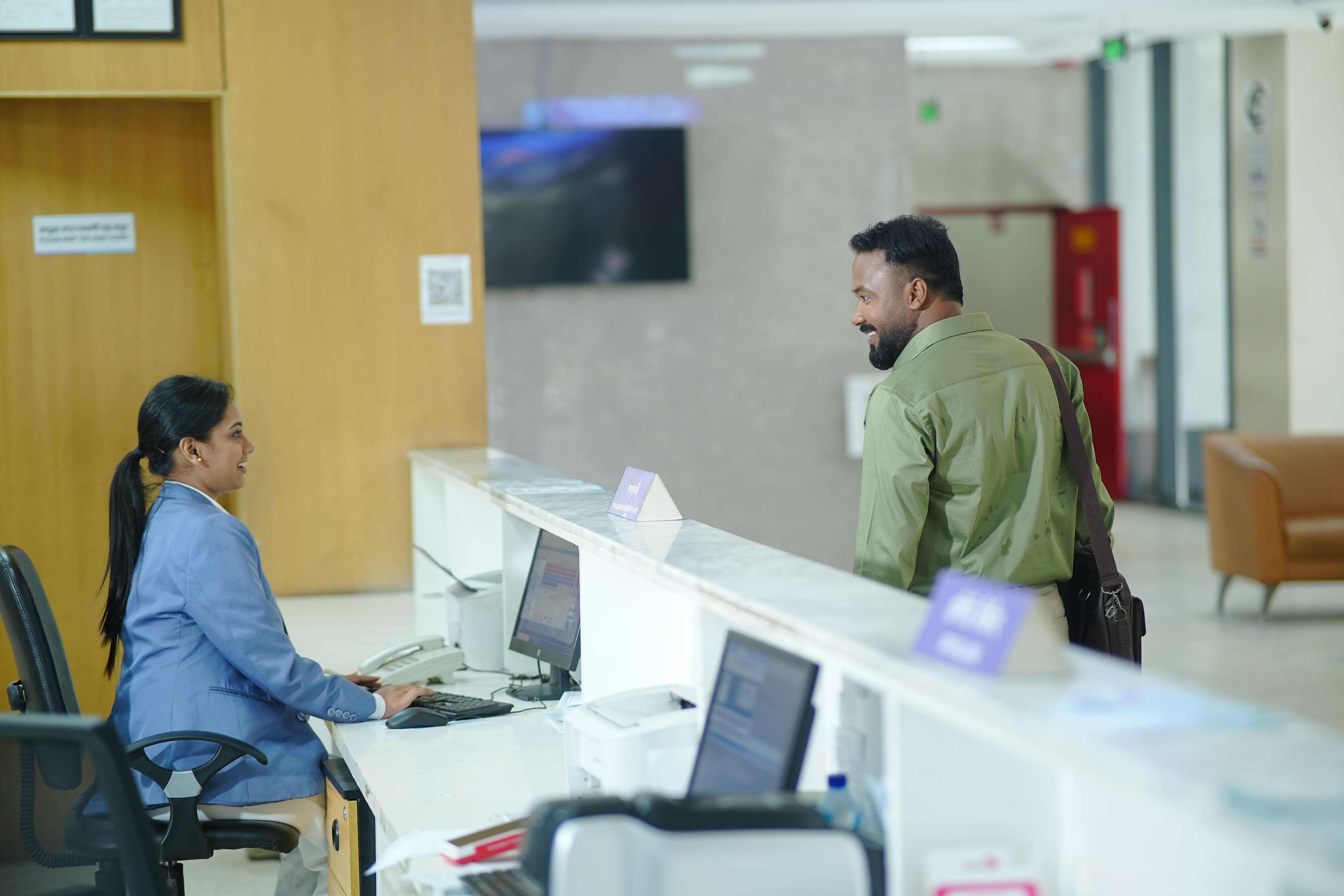 A front desk receptionist helping a guest with their stay